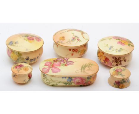 A collection of Royal Worcester lidded pin pots of various sizes, hand painted floral decoration on a blush ivory ground, puc
