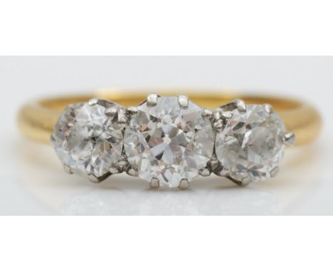 An Edwardian three stone diamond ring, claw set with old cut brilliant stones, weighing approximately 0.35, 0.60, 0.35cts, G/