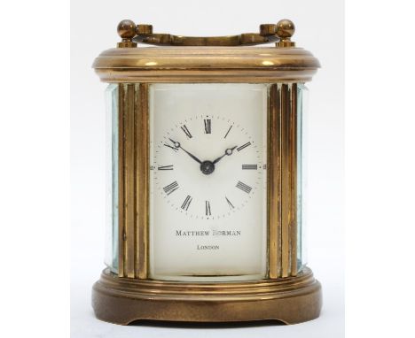 A brass eight day carriage clock of oval form, retailed by Matthew Norman of London. 8cm tall. 