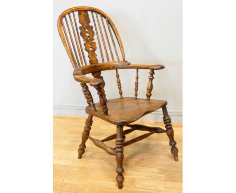 A 19th century elm and yew wood hoop back Windsor chair, the stick back centred with a pierced splat over a shaped seat and b