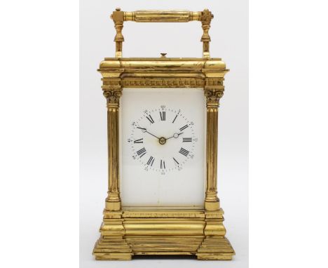 An early 20th century brass striking and repeating carriage clock, white enamel dial, ornate case with corinthian columns and