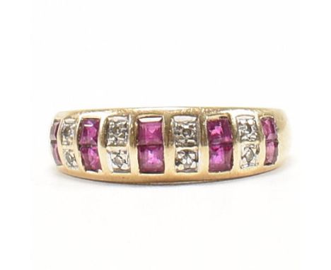 A hallmarked 9ct gold, synthetic ruby and diamond ring. The dress ring having ten princess cut synthetic rubies and a tapered