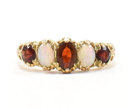 A hallmarked 9ct gold garnet and opal five stone ring. The ring having three rubies to include a central oval cut ruby and tw