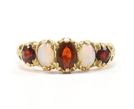 A hallmarked 9ct gold garnet and opal five stone ring. The ring having three rubies to include a central oval cut ruby and tw