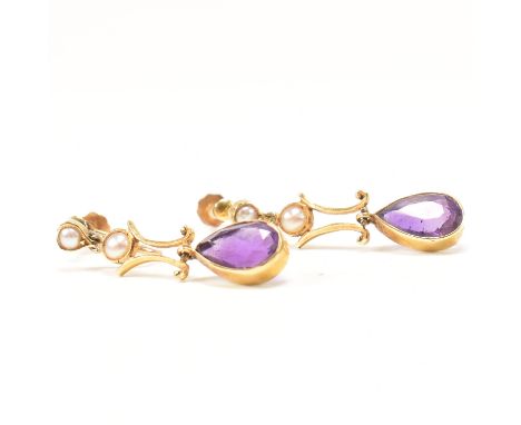 A pair of Edwardian gold amethyst and pearl pendant earrings. The earrings set with bezel set pear cut amethysts and two grad