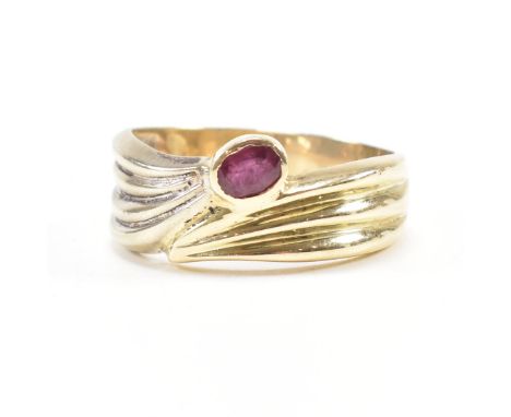 A vintage 14ct bi colour gold and ruby crossover ring. The two tone ring having a bezel set oval cut ruby to the white and ye