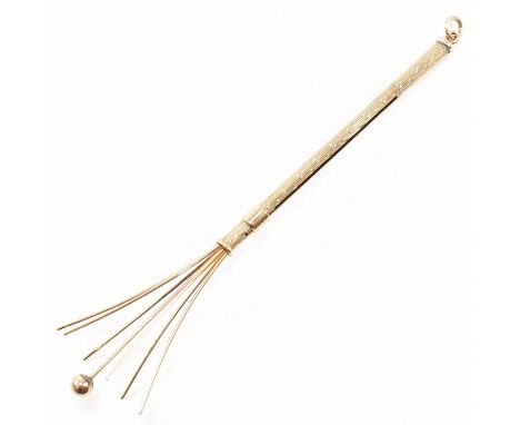 A retro hallmarked 9ct gold champagne swizzle stick fob.  The vintage cocktail stirrer having a tubular form with a slider to