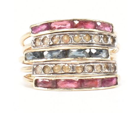 A gold, sapphire, ruby and spinel multi strand ring. The ring having five channel set rings united at the shank. Unmarked, ho