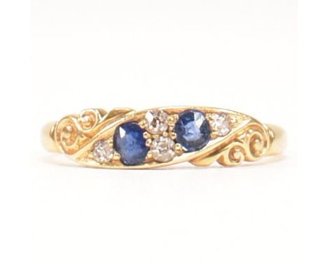 An antique hallmarked 18ct gold, sapphire and diamond two stone ring. The ring having two channel set oval cut sapphires flan