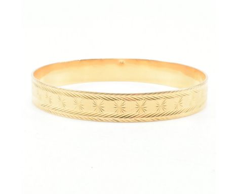 An antique 18ct yellow gold bangle bracelet. The bangle of circular form having etched repeating pattern throughout. Marked 1