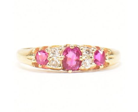 A gold, ruby and diamond ring. The ring set with a central oval cut ruby flanked by two round cut rubies and four round cut d