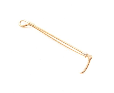 A 1920s platinum and 9ct yellow gold brooch pin. The horse riding equestrian interest brooch in the form of a riding crop wit