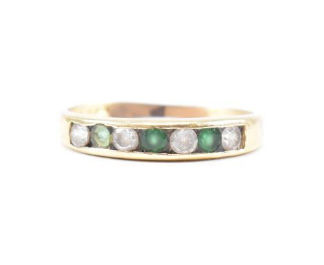 An Italian emerald and CZ half eternity ring. The ring having three round cut emerald with CZ in the channel setting head to 