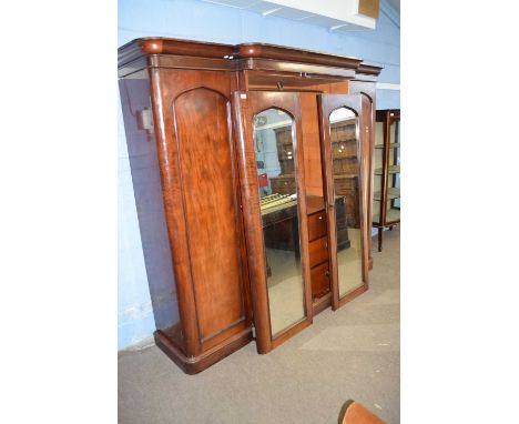 Victorian mahogany break front wardrobe with moulded cornice over two central mirrored doors and two panelled side doors, the