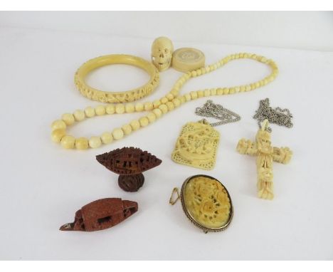 A collection of ivory items to include a bead necklace, a carved bangle, a pot and cover and other items; together with two c