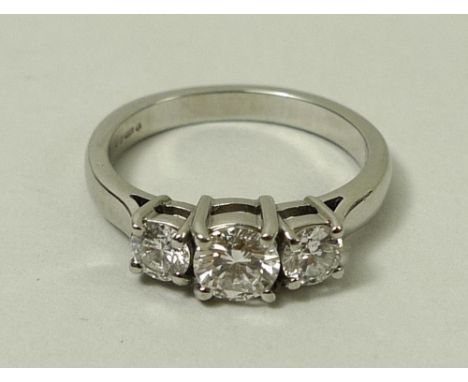 A platinum and three stone diamond ring, the central stone flanked either side by two smaller stones, 0.7ct total diamond wei