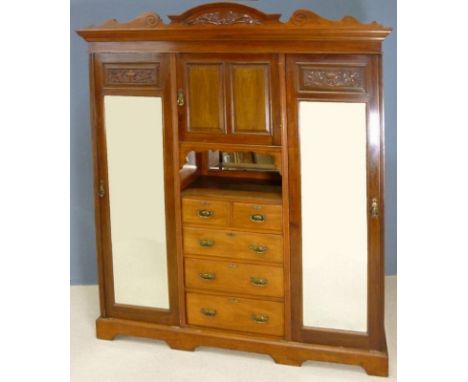 A Victorian mahogany wardrobe compactum, a two door cupboard over shelf and five drawers with brass handles, flanked by two f