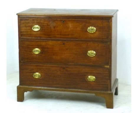 A George III mahogany chest of three long graduated drawers, with cast brass oval plaque handles and cock beading, raised on 