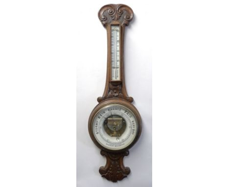 An aneroid barometer, W Pollard Canterbury, in an oak carved case, 26 by 86cm.