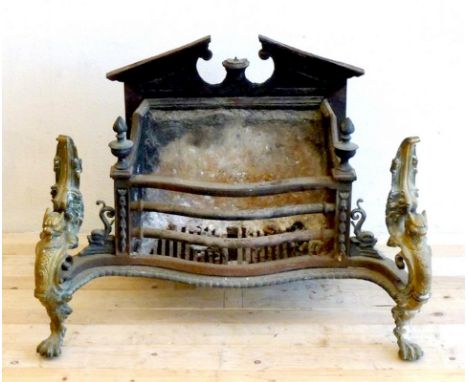 A 19th century fireplace grate with serpentine shaped front, decorated with cast brass griffin supports with paw feet, and a 