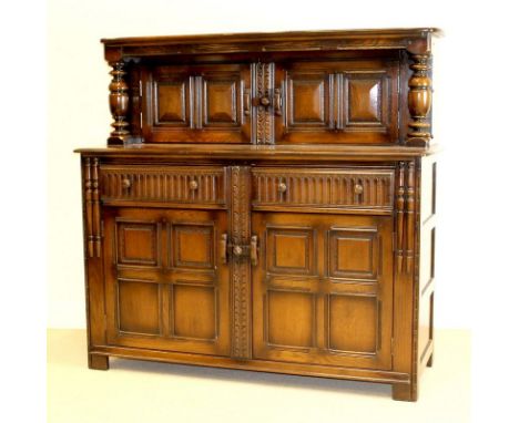 An Ercol oak court cupboard, dark stained, with two drawers, 145 by 57 by 138cm high.