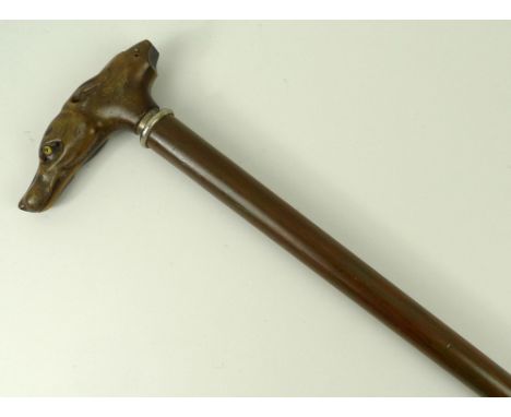 A walking stick, early 20th century, the horn handle carved with a greyhound and whistle, unscrewing to reveal a corkscrew, 8