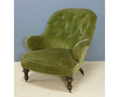 A Victorian button back nursing chair with outswept back and legs, raised on turned front legs with ceramic casters, 85 by 96