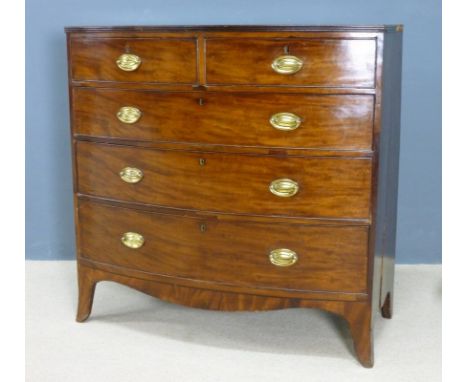 A Regency mahogany bow fronted chest of two short over three long graduating drawers with brass oval plate handles and cock b