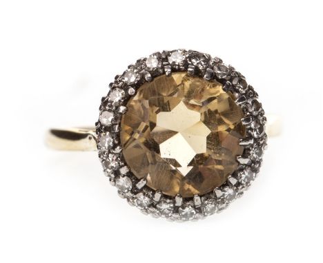 YELLOW GEM AND DIAMOND RING, set with a central round faceted yellow gem 13mm diameter within a diamond halo, in eighteen car