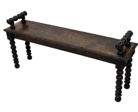A 19thC oak window stool, with bobbin turned handles and an outer leaf carving, on turned legs, 57cm H, 121cm W, 28cm D. 