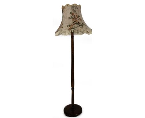 A 20thC oak stained standard lamp, with turned stem, circular base and floral shade, 181cm H.