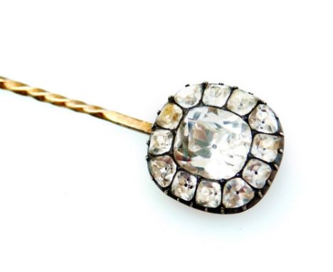 A Victorian stick pin, set to the top with white paste stones, with larger stone to the centre surrounded by twelve smaller s