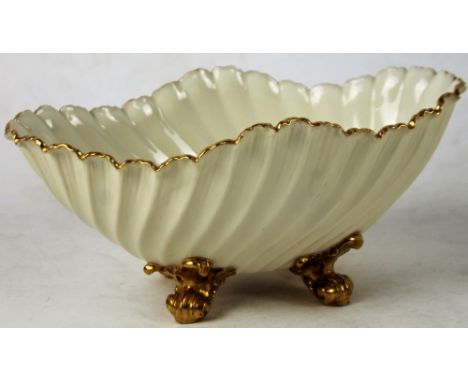 A late 19thC Royal Worcester porcelain shell shaped dish, with a ribbed body and gilt highlights, on scroll feet, purple mark