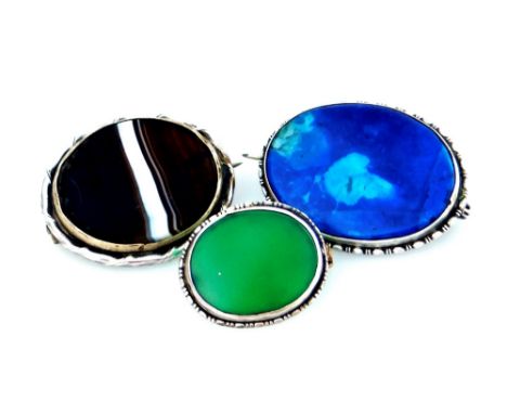 Three silver natural stone set brooches, to include a bull's eye agate brooch, in wavy design silver border, 3cm W, a lapis l