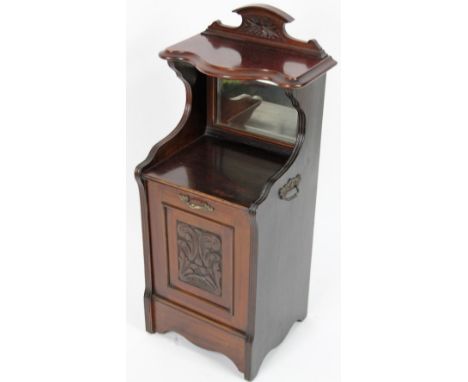 An Edwardian stained coal purdonium, the shaped back carved with flowers above a serpentine shelf, with hinged front door, fl