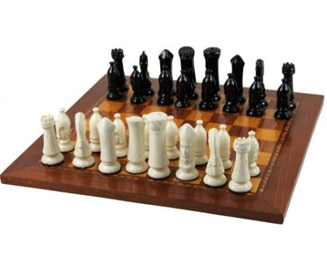 A 20thC ceramic chess set, each king 12cm H, on a parquetry board.
