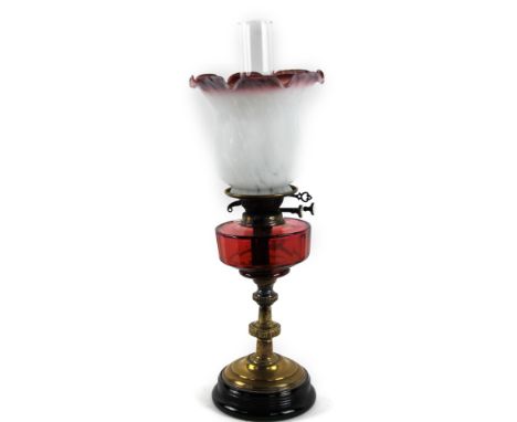 A Victorian oil lamp, with Sid White glass shade, cranberry reservoir and brass stem, with plain glass chimney, 60cm H. 