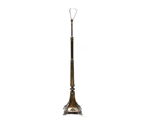 An Edwardian brass standard lamp, circa 1910, with a reeded column and obelisk-shaped body, on a square flared base with foli