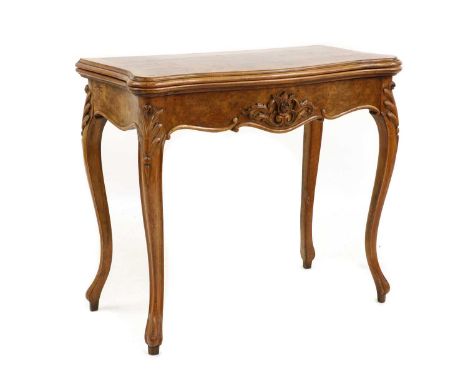 A Victorian burr walnut card table, with a shaped top, on cabriole legs each with a carved acanthus leaf to the top, the fold