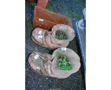 A pair of terracotta boot planters and a trough.
