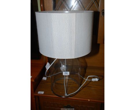 A modern clear glass table lamp and shade.