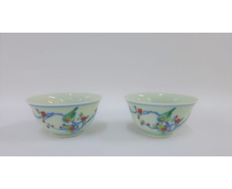 Pair of Chinese tea bowls with five colour enamels depicting birds, flowers, foliage and rock work, bearing six character Yon