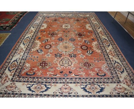 A large Persian pink ground carpet, woven with medallions and stylised flowers and leaves, approx. 410 x 290cm