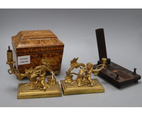 A William IV penwork tea caddy, a pair of ormolu Bacchanalian cherub candlesticks, lacking sconces and a hardwood dish stand