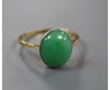 An 18ct and oval cabochon jade set ring, size Q, gross 2.8 grams.CONDITION: Tiny split on side of setting. Underside of stone