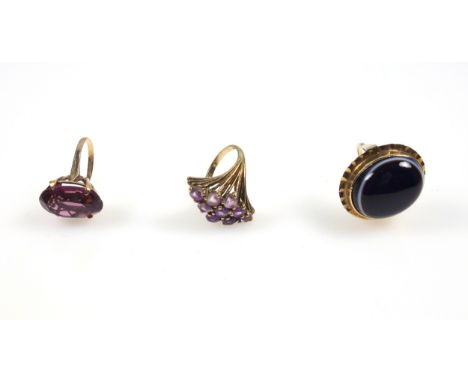 Yellow metal ring set cabochon agate, 2.2 x 1.8cm; 9ct ring set amethysts, and another ring set paste stone, gross 23.1grs. (