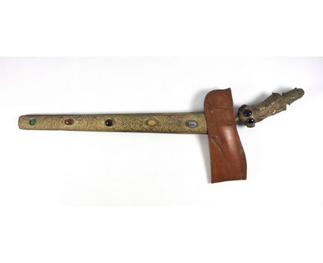 Indonesian Kris with a wavy blade, in an embossed brass scabbard with foliate decoration, set polished coloured stones and gl