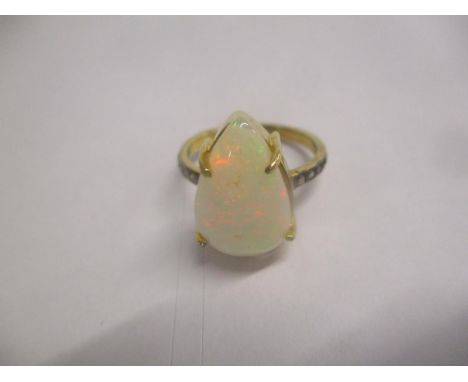 A silver gilt ring set with an opal and diamonds to the shoulders 