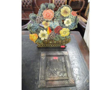 A painted metal fire guard in the form of a basket of flowers and an embossed vintage metal plaque 