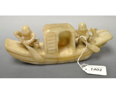 A carved jade boat, two figures aboard.